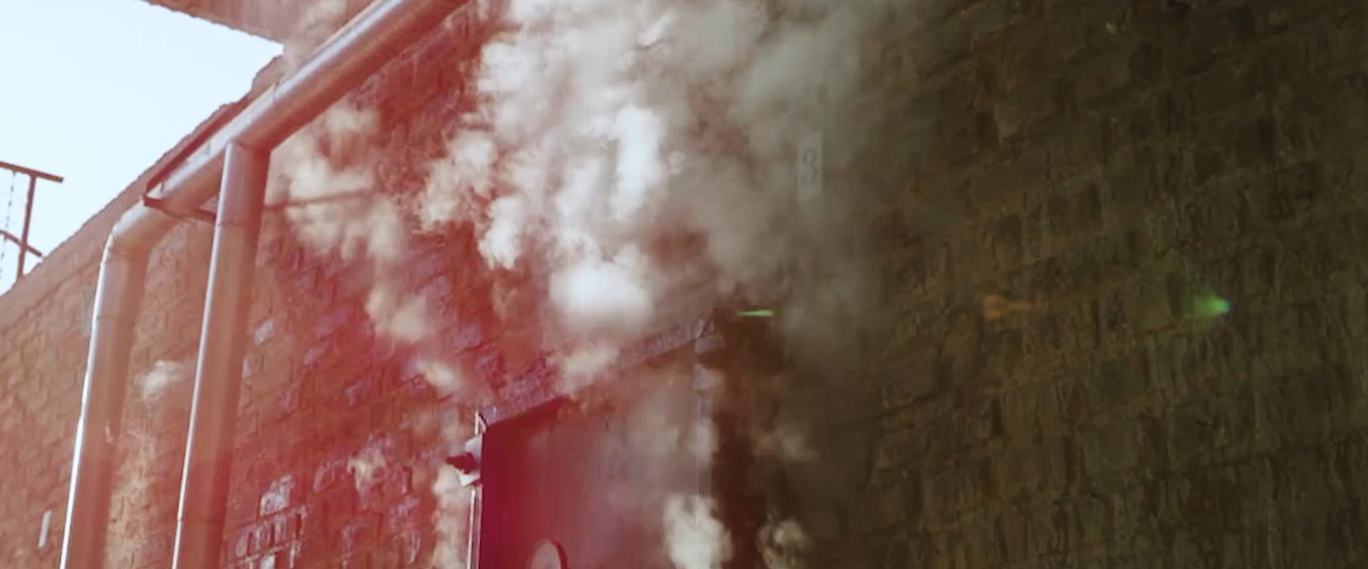 Smoke rising out of the door of the El Viejito Distillery in Mexico, where Santo Mezquila mezcal tequila is made.